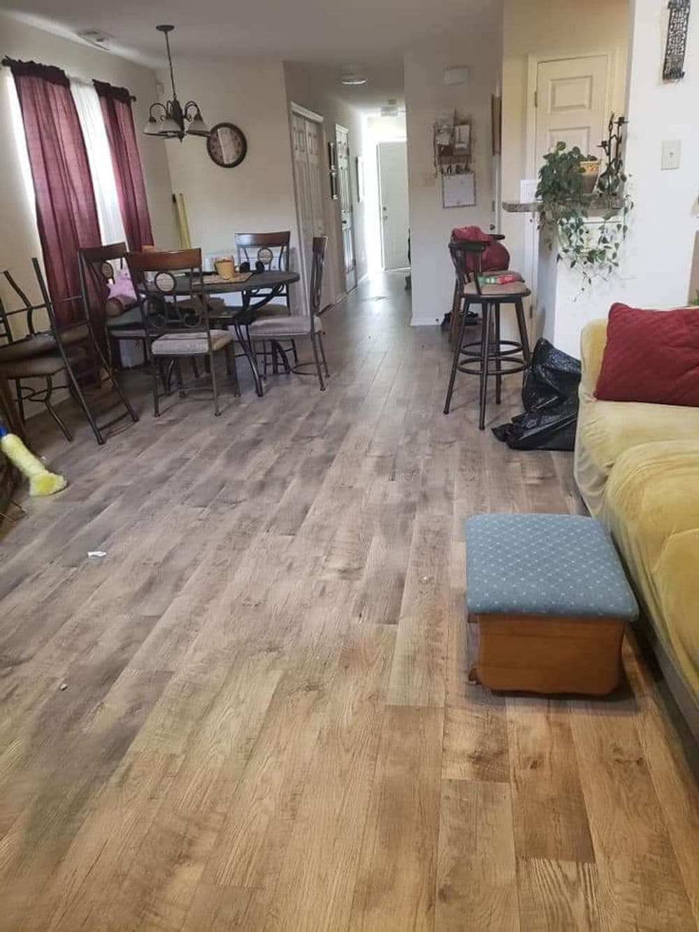 Living room with wooden floors, dining table, and chairs, featuring a yellow object and cozy seating area.